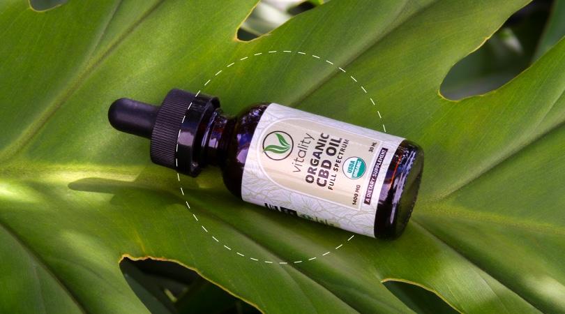 Bottle of Vitality CBD oil on top of a leaf
