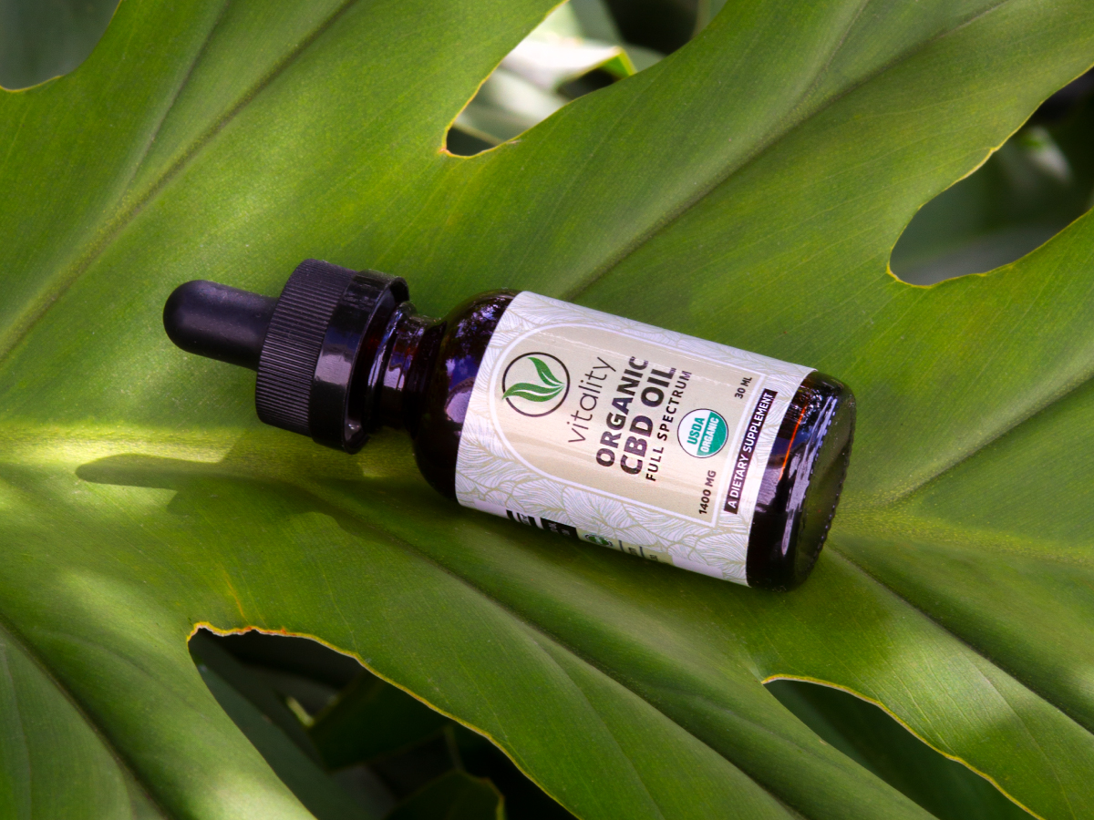 Bottle of Vitality CBD oil on top of a leaf