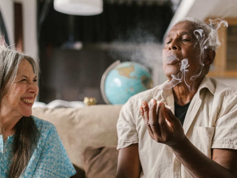 Couple in around their 60s sharing a Delta-8 flower joint.