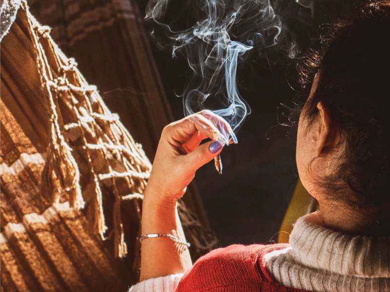 Woman holding a joint with Delta-8 flower mixed with shatter.