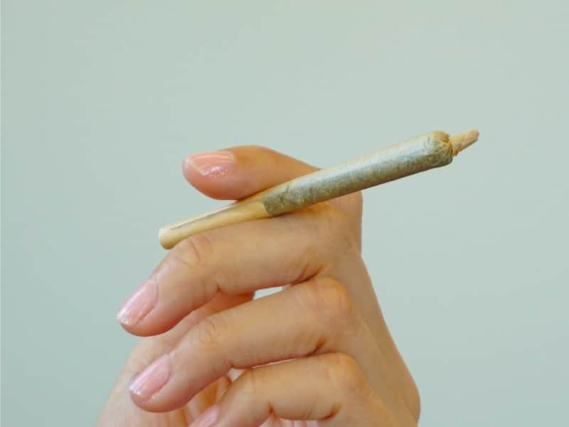 Hand holding a Delta-8 joint.