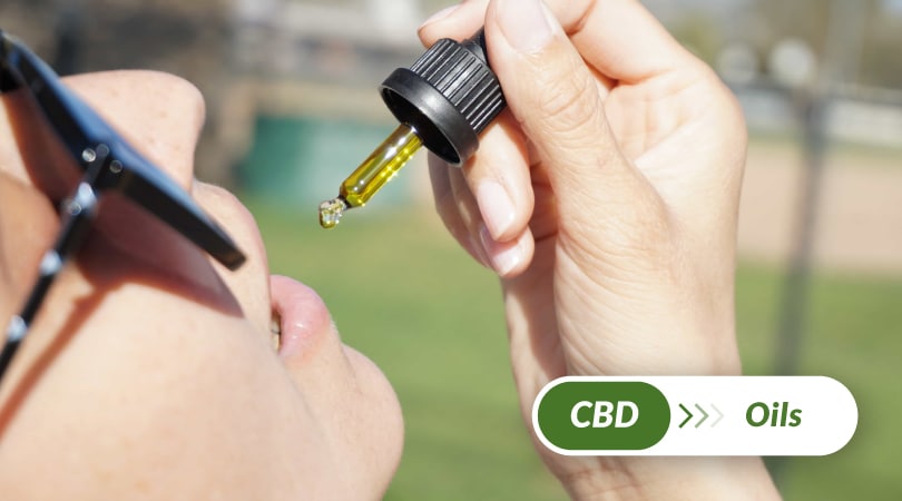 Woman about to ingest a dropper full of CBD.