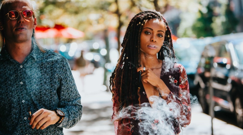 Man and woman walking on the street and vaping Delta-8 carts.