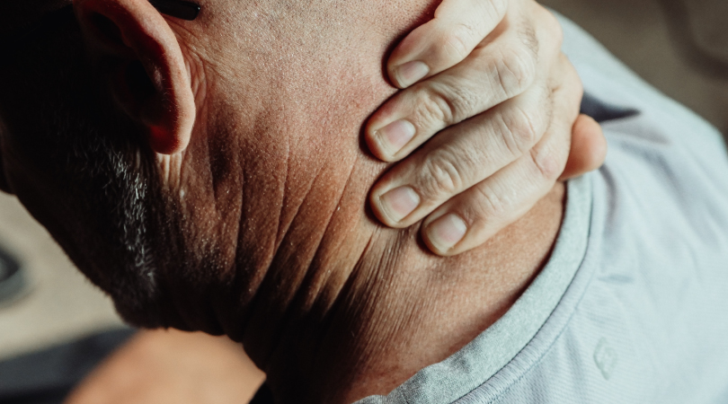 Man holding the back of his neck to ease pain.