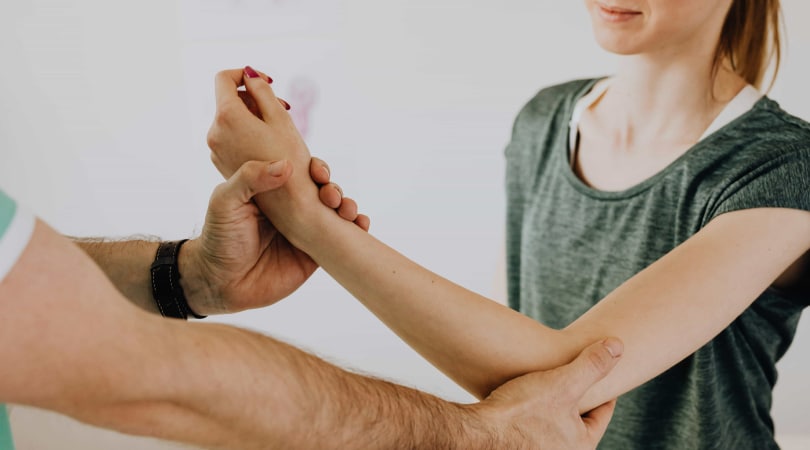 Woman getting a massage on her elbow due to tendonitis.