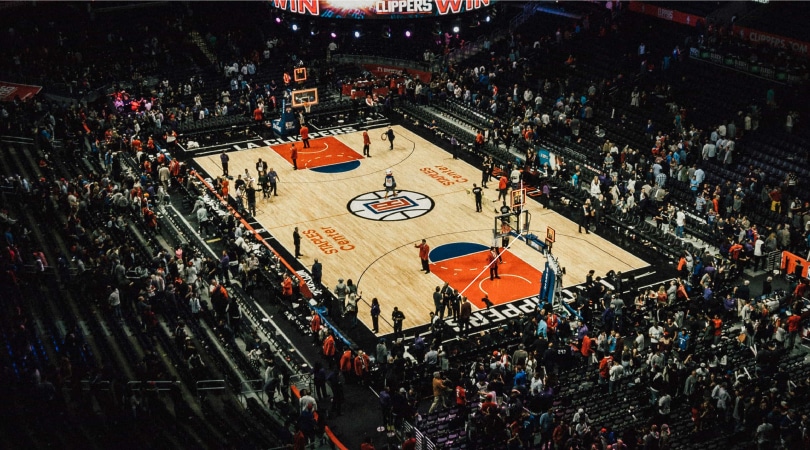 Players in a basketball court and fans watching.