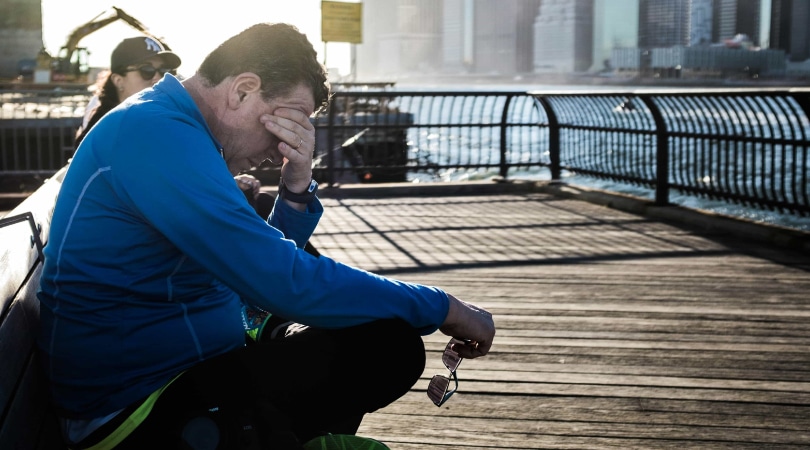 Man sitting on a bench and feeling tired.