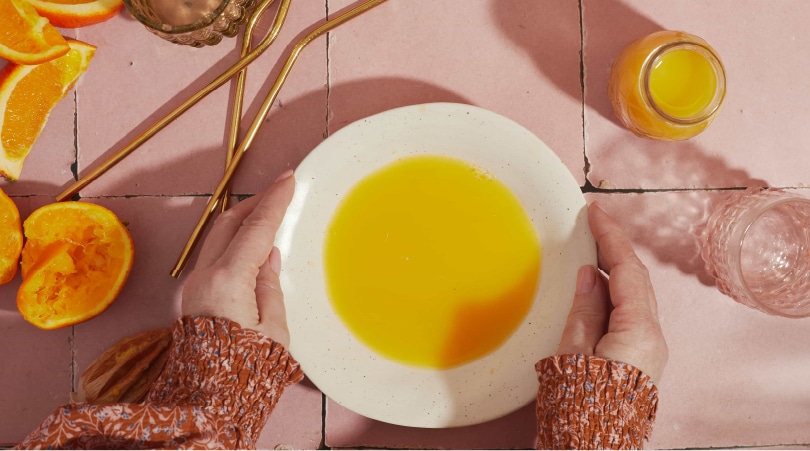 Hands holding a plate with a mix to make Delta-8 gummies.