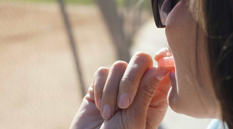 Woman holding a Delta-8 gummy and ready to start eating it.