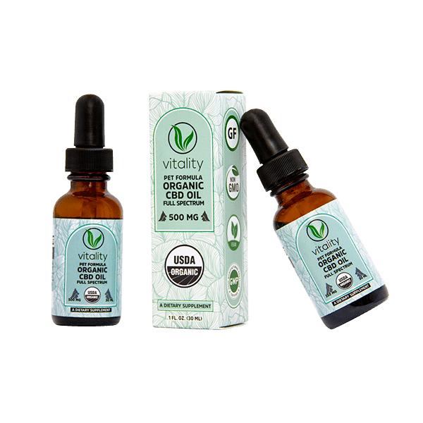 Two bottles of Vitality CBD oil for pets next to the package they come in.